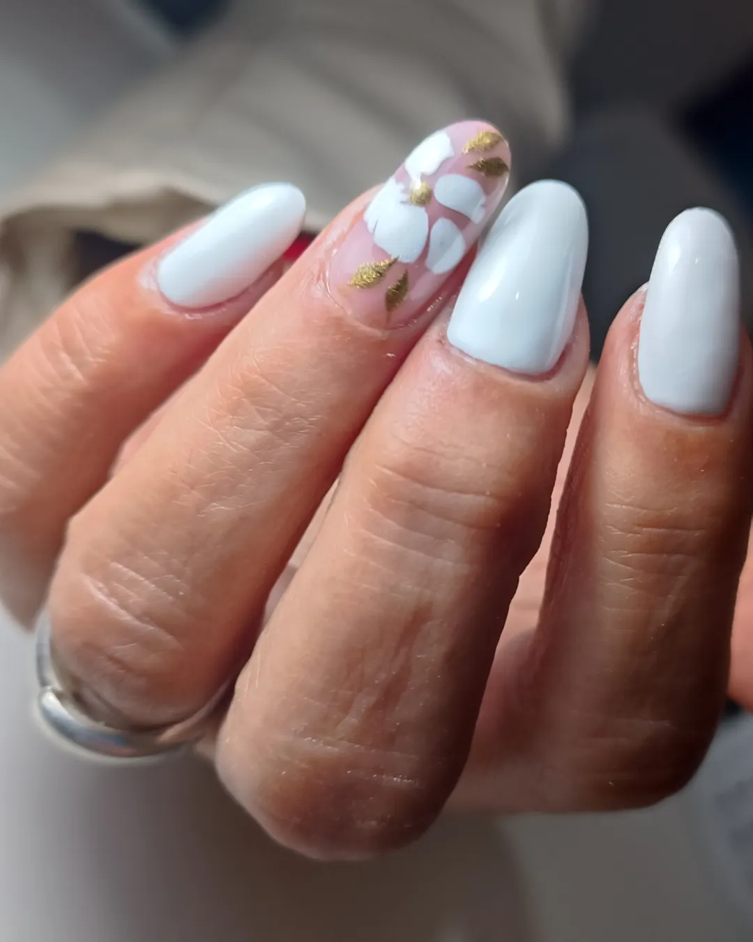 Uñas gris perla con una flor blanca pintada a mano